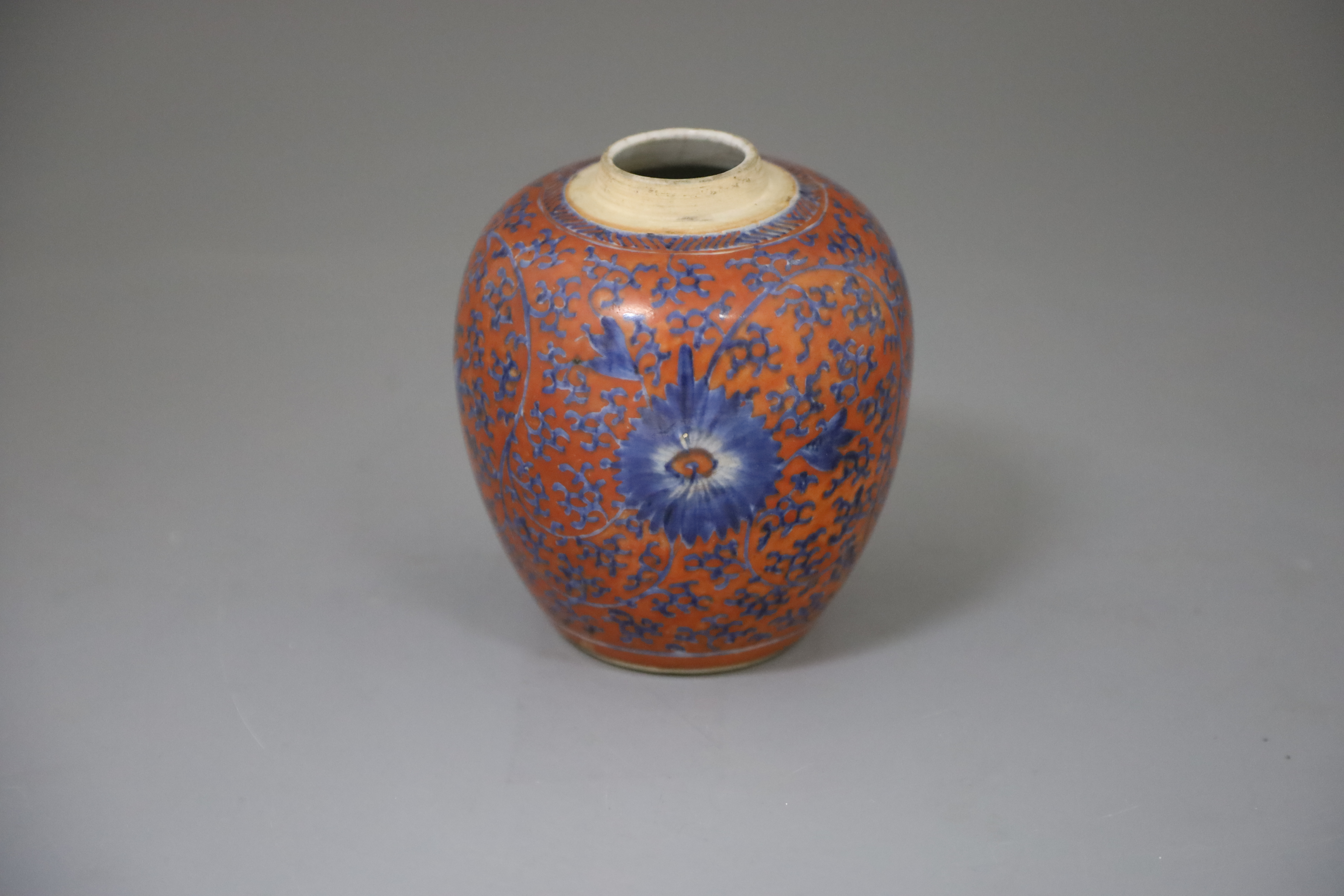 A Chinese coral red ground underglaze blue jar, Kangxi period, H. 12.3cm, excluding wood cover and stand